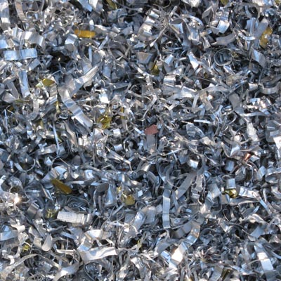 Small metallic silver and gray aluminum filings and shavings scattered densely, viewed from above