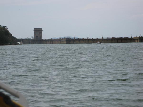 Water view with concrete dam or bridge structure in background, taken from a boat
