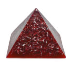 orgonite pyramidale transparente avec copeaux métalliques rouges et bandes ondulées incrustées, vue de face