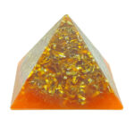 Orange und klares Harz-Pyramid mit eingebetteten goldenen Metallspänen, von vorne gegen weißen Hintergrund