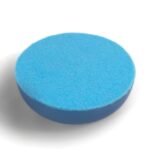 Runde blaue orgonite Scheibe mit hellblauer Oberseite und dunkleren blauen Seiten, leicht schräg auf weißem Hintergrund