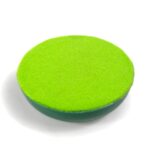 Runde grüne orgonite Scheibe mit hellgrüner Oberfläche und dunkelgrünem Rand, von oben auf weißem Hintergrund fotografiert