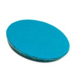 Ovale blaue orgonite-Platte mit glatter Oberfläche und strukturierter rauer Kante, leicht angewinkelt auf weißem Hintergrund