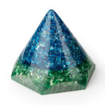 Blue and green orgonite pyramid with metallic flakes and clear resin, viewed at angle against white background
