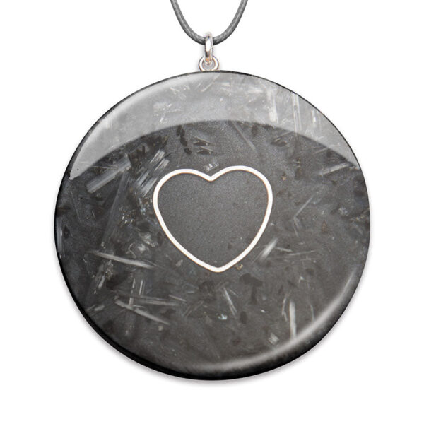 Pendentif rond gris foncé avec contour de cœur blanc au centre, suspendu à une chaîne argentée sur fond blanc