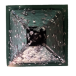 Pirámide cuadrada verde con partículas plateadas metálicas y trozos negros de shungite incrustados, vista desde arriba