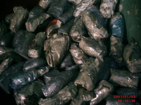 Large pile of fresh mussels or similar shellfish with dark shells, some showing reddish coloring inside
