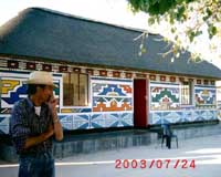 Kevin Mentenari in front of Esther Mahlungu‘s house on Ndebele Orgone expedition