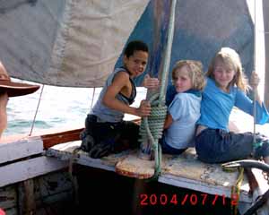 3 kids sitting in a boat